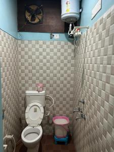 baño con aseo y tanque de agua en mshotel Loharu, en Lohāru