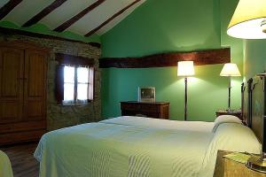 La Casa de las Monjas في Miranda de Arga: غرفة نوم مع سرير وجدار أخضر