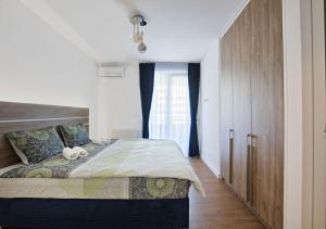 een slaapkamer met een bed en een groot raam bij Sarajevo Waves Aparthotel in Sarajevo