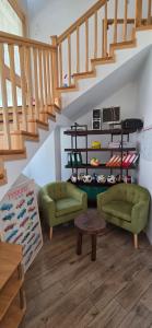 ein Wohnzimmer mit 2 grünen Stühlen und einer Treppe in der Unterkunft Munich Residence in Cristian