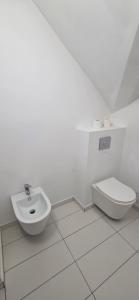 ein weißes Bad mit einem WC und einem Bidet in der Unterkunft Munich Residence in Cristian