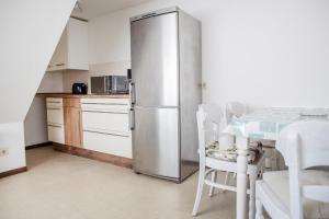 a stainless steel refrigerator in a kitchen with a table at Markt Eins Appartement Stadtblick in Schöppenstedt
