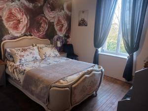 a bedroom with a bed with a flower mural on the wall at Cherry Blossom House in Bujaleuf