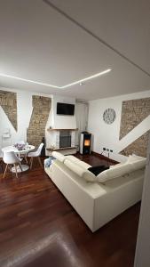 デセンツァーノ・デル・ガルダにあるAPPARTAMENTO LAKE GARDA ibiscus di Franciaの白いソファとテーブルのあるリビングルーム