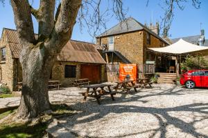 a group of picnic tables in front of a building at The Sun Inn At Hook Norton in Banbury