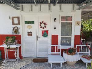 AmbaritaRuma Kaca Simanindo Bed&Breakfast的房屋的前门,房子配有两把椅子和一张桌子