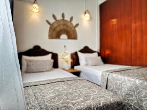 Vintage 90s Port Louis apart near Jeetoo Hospital في بورت لويس: غرفة نوم بسريرين وجدار