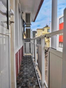 Vintage 90s Port Louis apart near Jeetoo Hospital في بورت لويس: ممر فاضي لمبنى مع بلكونه