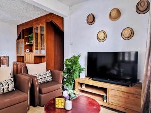 Vintage 90s Port Louis apart near Jeetoo Hospital في بورت لويس: غرفة معيشة مع تلفزيون وأريكة وطاولة