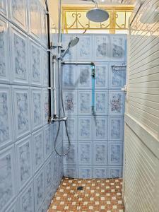 Vintage 90s Port Louis apart near Jeetoo Hospital في بورت لويس: حمام به دش وبه جدران من البلاط الأزرق