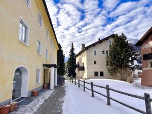 a snow covered alley with buildings and a fence at Chesa Principela - La Punt in La Punt-Chamues-ch
