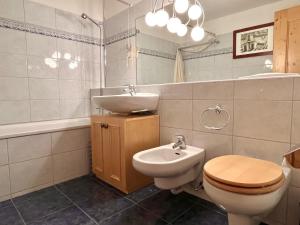 Un baño con un lavabo y un inodoro y un lavabo. en Chesa Principela - La Punt, en La Punt-Chamues-ch 16 fotos más