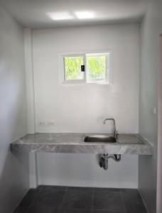 a kitchen counter with a sink and a window at Naranta House in Ko Raeng