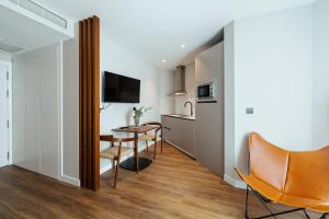 cocina pequeña y comedor con mesa y sillas en Apartamentos 2H LIVING, en León