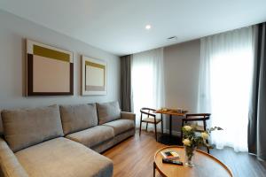 una sala de estar con un sofá y una mesa en Apartamentos 2H LIVING, en León