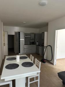 una cucina con tavolo bianco con sedie e una cucina di AGREABLE T3 1er étage a La Celle-sous-Gouzon