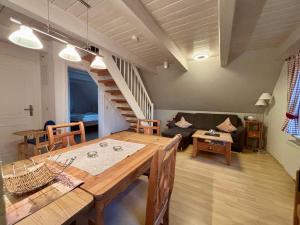 a living room with a dining table and a couch at Adlerhorst - Moderne 60 qm Wohnung mit Terrasse in Oevenum
