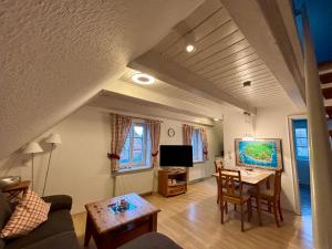 a living room with a table and a tv at Adlerhorst - Moderne 60 qm Wohnung mit Terrasse in Oevenum