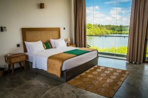 a bedroom with a large bed and a large window at Six Elements Beach Villa in Tangalle