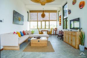a living room with a couch and a table at Six Elements Beach Villa in Tangalle