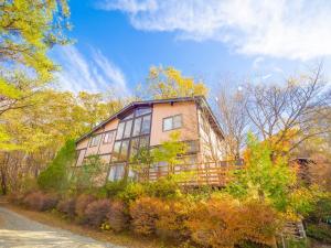 a large house on top of a hill with trees at Beautiful Nasu, the center of Nasu, Up to 12 people, 3 bedrooms, BBQ on the deck, night karaoke in Nasu