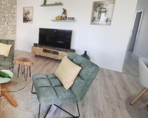 ein Wohnzimmer mit Sessel und Fernseher in der Unterkunft Sugar Apartment 41A in Trnava + 3 Fotos