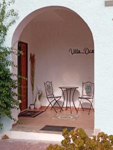 un patio con 2 sedie e un tavolo in un edificio di TABERNA ROMANA VILLA OCA b&b a Velletri