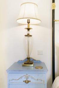 Valletta Townhouse Suite with a Maltese Balcony في إيل فورجانا: مصباح على طاولة زرقاء بجوار سرير