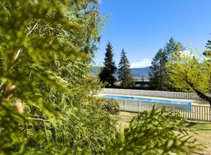 une piscine avec une clôture et des arbres dans l'établissement El racó de Montana Park, à Enveitg