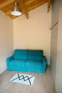 un divano blu in soggiorno con tappeto di Petit chalet avec piscine privée a Lumbin