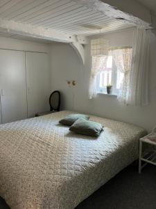 a bed with two pillows on it in a bedroom at Madam Bundsens Huse in Assens