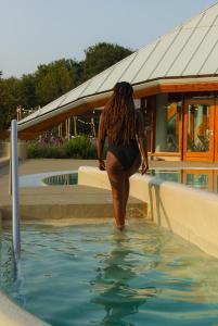 Eine Frau geht in einen Wasserpool in der Unterkunft Wellnesshotel Thermae 2000 in Valkenburg