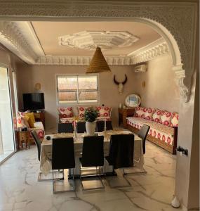 una sala de estar con una mesa, sillas y un sofá en philippe ayache, en Marrakech