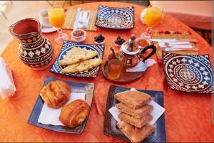 Una mesa cubierta con platos de comida y bebidas de naranja. en philippe ayache, en Marrakech