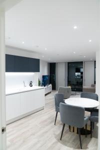 a kitchen and dining room with a table and chairs at Modern 2 Bed Penthouse with Stunning views in Manchester City Center in Manchester