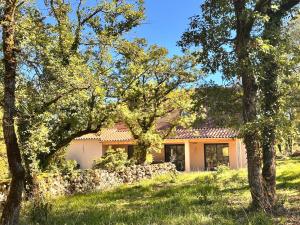 una casa con un muro in pietra e alberi di Gîte du Causse d'Autoire ad Autoire