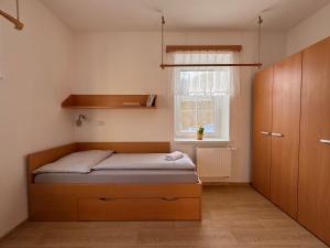 mała sypialnia z łóżkiem i oknem w obiekcie Chata Eliška w mieście Loučná nad Desnou