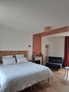 Saint-Rémy-la-VarenneLes chambres de Marcel的一间卧室，有一张大床和一把蓝色椅子