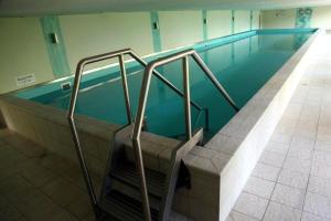 an empty swimming pool with stairs in a building at Seeappartement Ingrid in Bodensdorf
