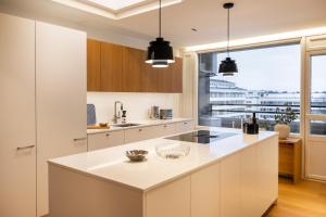 une cuisine avec comptoirs blancs et une grande fenêtre dans l'établissement Penthouse Ounas with Private Sauna, à Rovaniemi