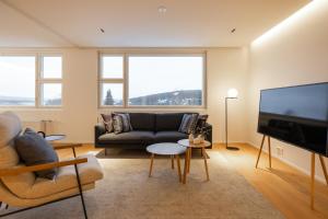 un salon avec un canapé et une télévision dans l'établissement Penthouse Ounas with Private Sauna, à Rovaniemi