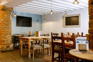 a dining room with tables and chairs and a flat screen tv at The Sun Inn At Hook Norton in Banbury