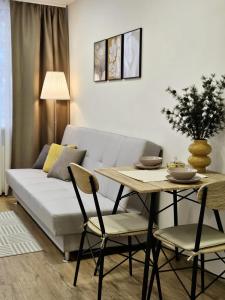 un soggiorno con un divano bianco e un tavolo di Airport & Station Stay Vilnius a VNO