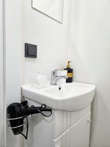 un bagno bianco con lavandino e specchio di Airport & Station Stay Vilnius a VNO