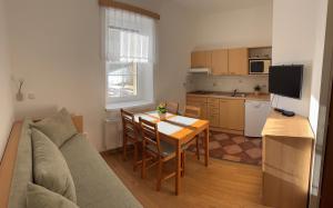 salon ze stołem i kanapą oraz kuchnia w obiekcie Chata Eliška w mieście Loučná nad Desnou