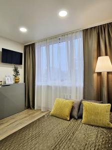 un soggiorno con un divano e una grande finestra di Airport & Station Stay Vilnius a VNO