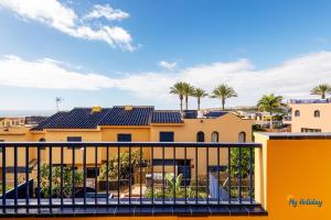 vue depuis le balcon d'un immeuble jaune avec des palmiers dans l'établissement Villa Meloneras III, à Maspalomas