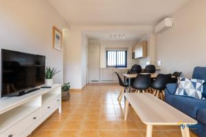 un salon avec un canapé bleu et une table dans l'établissement Villa Meloneras III, à Maspalomas