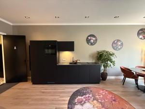 a kitchen with a black refrigerator and a table at Maastricht Suites - City Studio A in Maastricht +11 photos