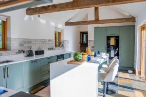 una cucina con armadi blu e ripiani bianchi di The Church Barn a Stratford-upon-Avon